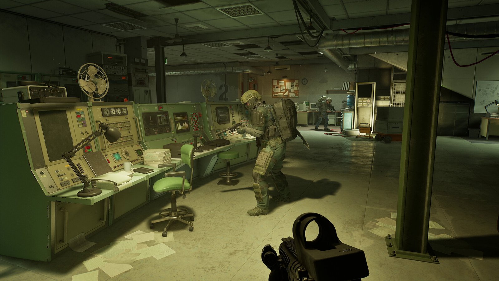 A first-person view of a heavily armored soldier holding a rifle and standing in a dimly lit, retro-style underground control room filled with old-fashioned server racks, blinking lights, and large consoles. Another soldier is operating the equipment, and a third is standing in the background.