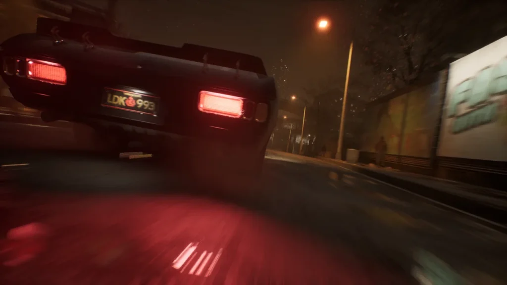 A low-angle, motion-blurred shot of a vintage muscle car speeding down a city street at night, with glowing red taillights reflecting off the pavement.